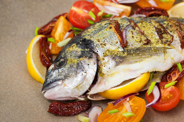 Raw whole sea bream fish and vegetables ingredients