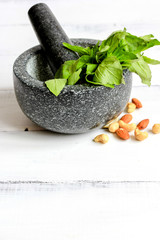 cooking spices in mortar home with nuts at wooden background