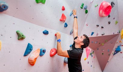young caucasian man rock climbing indoors