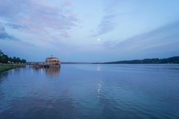 Obraz premium Moon over the river by the town