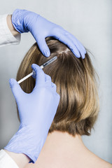 Doctor aesthetician makes head beauty injections to female patient