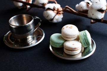 cup of coffee with french macaroon on dark background.