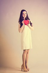Redhead girl with gift for Valentines Day. Photo bokeh at background
