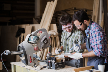 Two men builder with circular saw having a conversation