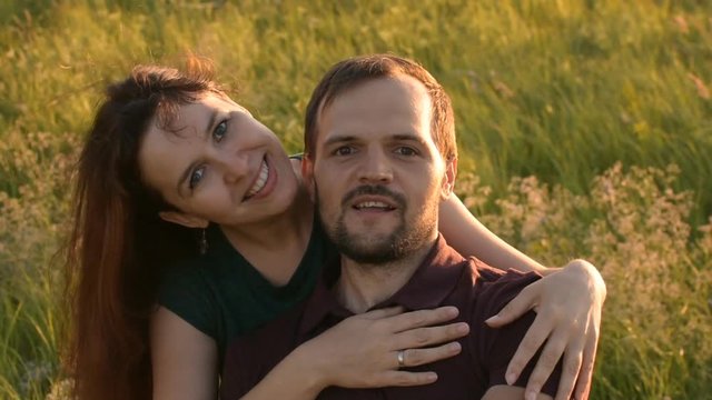 Happy couple walking in the Park at sunset and taking a selfie. Surprised, looking at the camera.