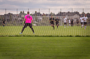 Male soccer goalie in the net preparing to make a save