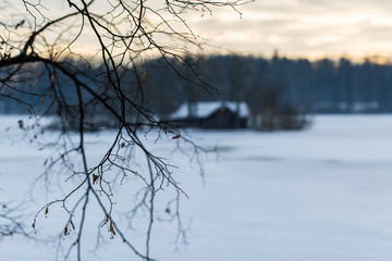 Fototapeta na wymiar hut on island in the middle of a frozen lake in winter