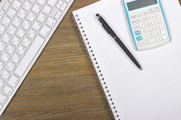 notebook keyboard, pen and calculator on the desktop