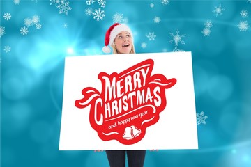 Beautiful woman in santa hat holding christmas placard