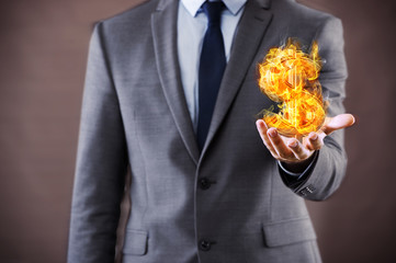 Businessman holding burning american dollar sign