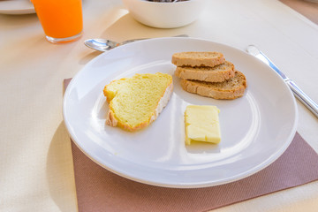 Breakfast including coffee, orange juce, bread, and butter.