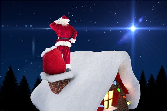 Digitally generated image of santa claus standing on house roof