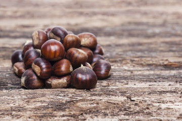 Raw chestnuts on wooden background