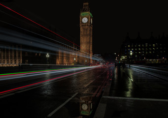 Fototapeta na wymiar Reflection of Big Ben in puddle with light trails across Westminster Bridge, London, UK.