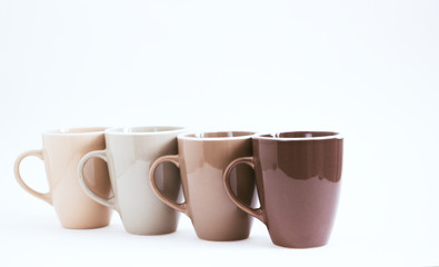 Four big cups on a white background. Not isolated, color gradation, selective focus