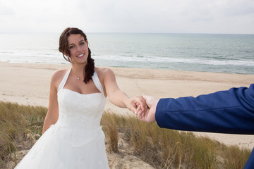 Fototapeta na wymiar Holding Hands with wedding rings on the background of sea