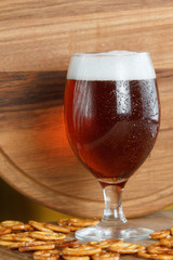 Glass of foamy beer alcohol with german pretzel. Traditional bavarian Oktoberfest snacks and drink