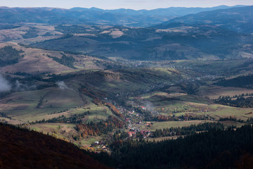 Fototapeta na wymiar Fog above the carpathian mountain valley in autumn