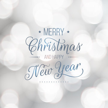 Merry Christmas and Happy New Year greeting card. Modern calligraphy lettering. Typographic vector design, beautiful light bokeh background, blurred festive lights.