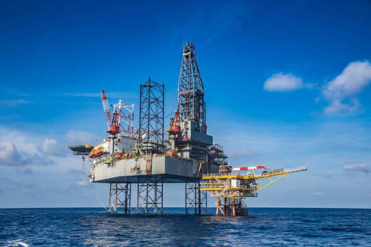 Offshore Oil And Gas Drilling Rig While Completion Well On Oil And Gas Wellhead Remote Platform To Running Pipe Line To Oil And Gas Reservoir, Oil And Gas Production And Exploration I.