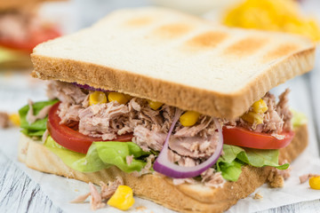 Wooden table with a Tuna Sandwich (selective focus)