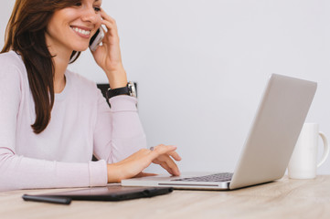 Profile portrait of a young smiling woman, talking on the phone,