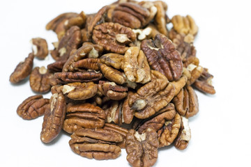 Pile of whole and bits of shelled pecans. White background. Horizontal.