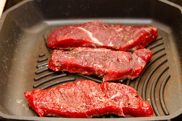 Slices of beef strip loin stir-fried in a skillet-grill, visible