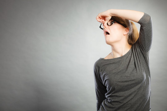 Nerdy girl holding nose.