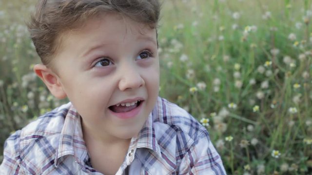 Portrait happy little boy sitting in the park at the day time