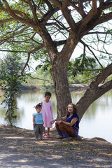 family with tree near lagoon