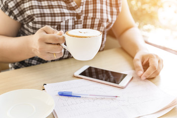 Female hand holding cup of coffee