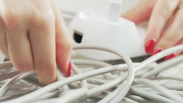 Woman Plugging a White Cable