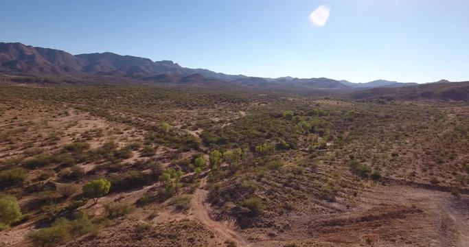 A high angle aerial daytime flyover establishing shot of the Arizona desert.  	