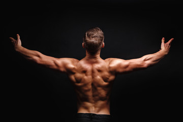 Fototapeta na wymiar Bodybuilder Posing. Muscles the shoulders and back.
