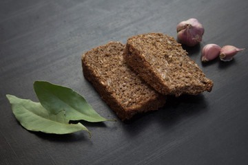 black bread, Bay leaf, garlic on a black background