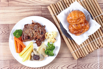 Home made ,Pork steak and mixed vegetables with croissants .