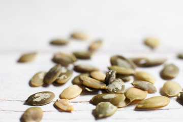 Pumpkin seeds on white background close-up. Texture of squash semen, agricultural backdrop