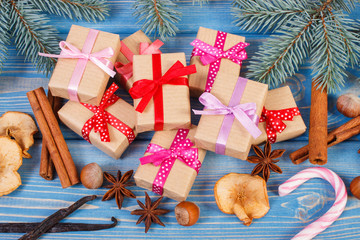 Wrapped gifts with ribbons for Christmas, spices and spruce branches