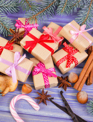 Wrapped gifts with ribbons for Christmas, spices and spruce branches
