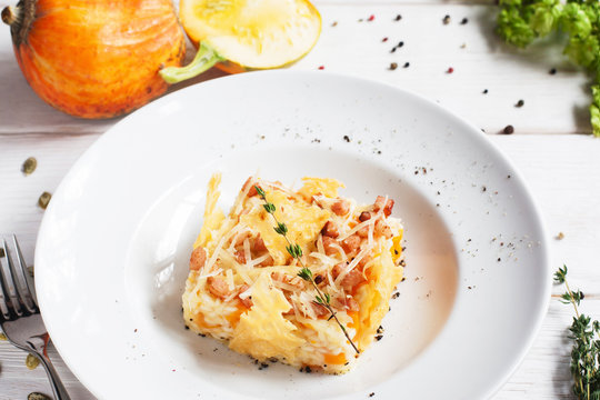 Rice casserole in cheese basket on plate. Tasty baked mix of rice and pumpkin with cheese. Restaurant food, seasonal menu, autumn cuisine concept