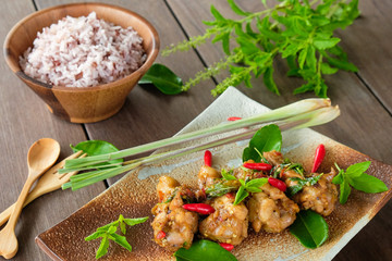 Stir-fried chicken with basil and rice on wood table