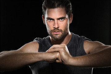 Athlete in gym posing fist and determined expression focused intensity dramatic fitness workout