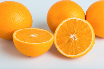 Fresh orange and cut in half on white background