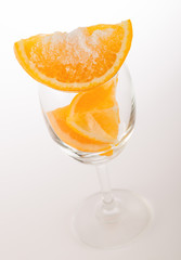 Fresh orange with salt in glass on white background