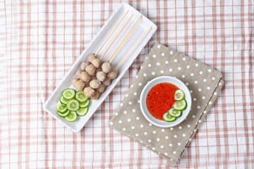 Grilled pork meatball skewers served cucumber and sweet chili sa