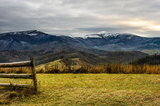 fence on the meadow in snowy mountains