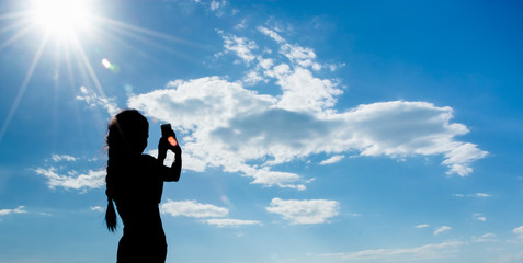 Silhouette women take a photo or selfie under blue sky