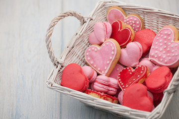 pink and red heart-shaped cookies in a square wicker basket close-up
