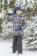 Fototapeta na wymiar Boy throw snowball. Wintertime fun